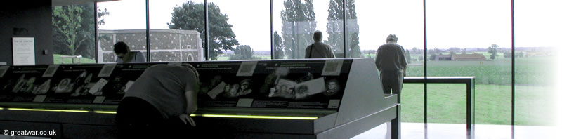 Inside the Visitors Centre looking through the panoramic window to the west and the city of 
		Ypres. The northernmost corner wall of Tyne Cot cemetery can be seen on the left.